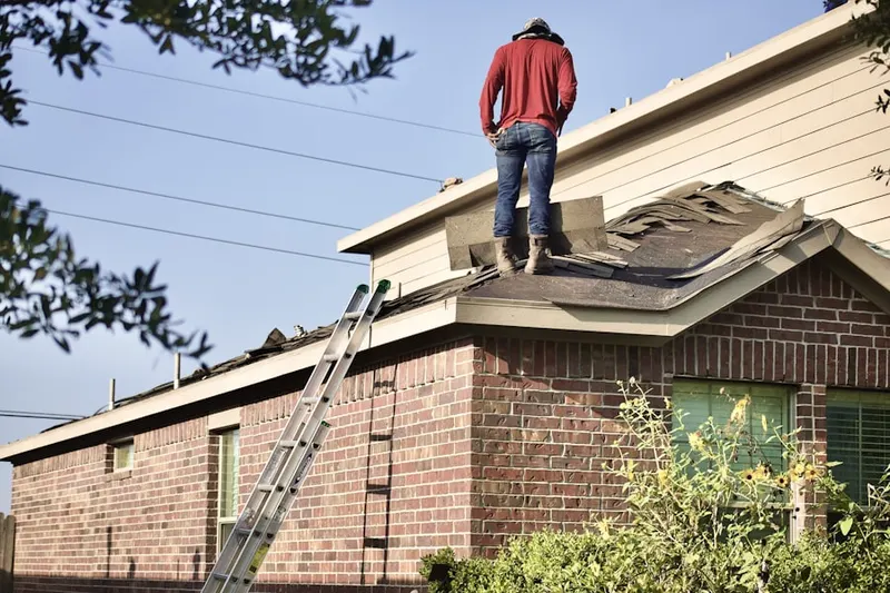 Professional roofer working on a residential roof in Village at Western Oaks